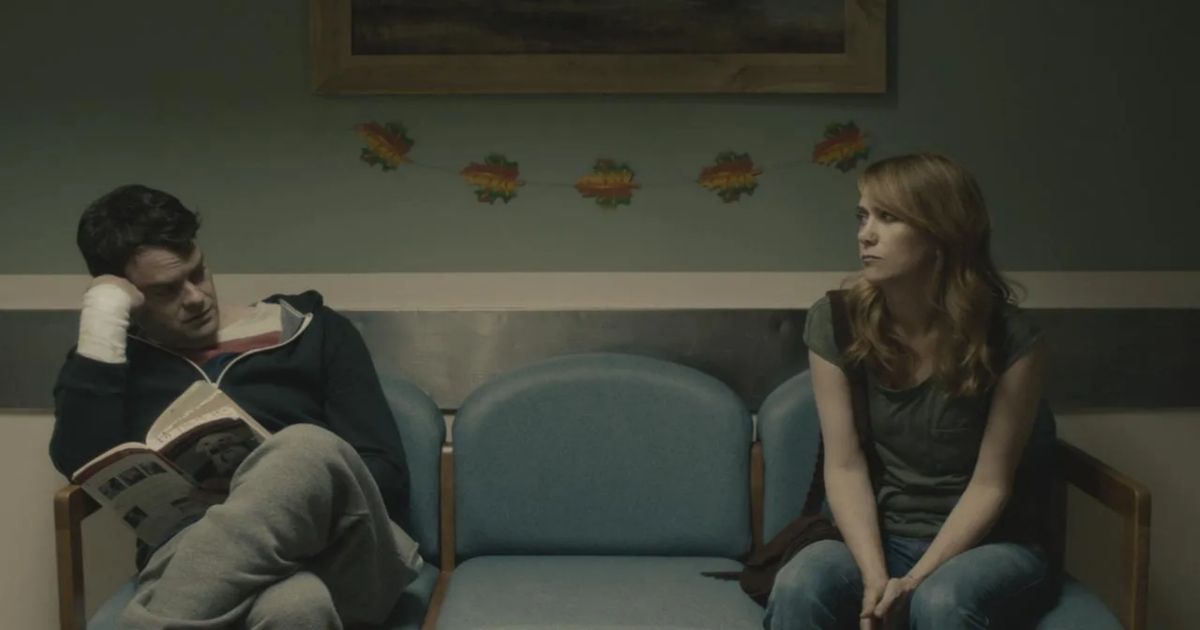 Hader and Wiig sit a chair apart and glance at each other in Skeleton Twins 