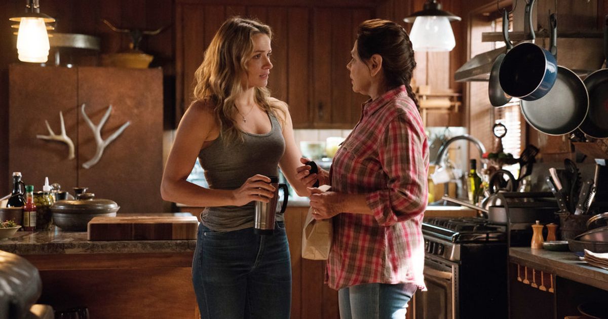 Julie and Anna stand together in the kitchen in Shooter